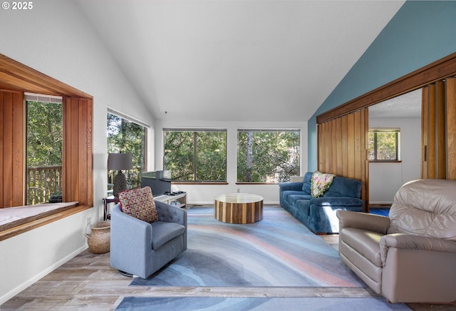 sunroom / solarium with lofted ceiling, wood finished floors, and baseboards