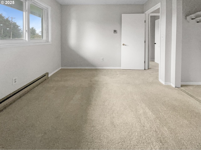 carpeted empty room with a baseboard radiator