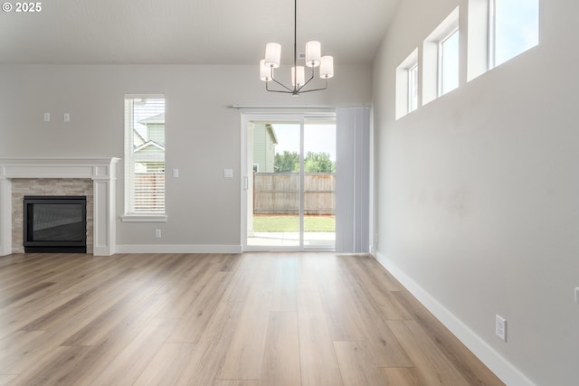 3237 Wildflower Dr, Springfield, OR 97478 - unfurnished living room with light wood-style floors, a chandelier, and a glass covered fireplace