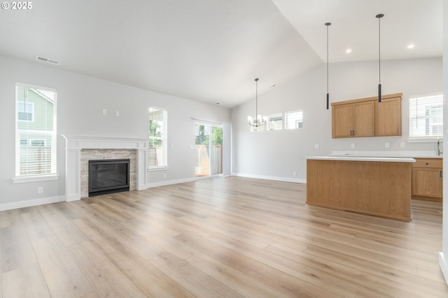 3237 Wildflower Dr, Springfield, OR 97478 - unfurnished living room featuring a chandelier, light wood-type flooring, a stone fireplace, recessed lighting, and high vaulted ceiling