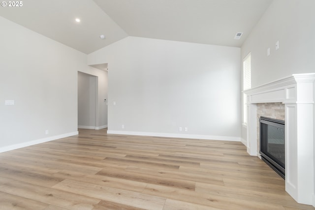 3237 Wildflower Dr, Springfield, OR 97478 - unfurnished living room featuring lofted ceiling, a glass covered fireplace, and light wood-type flooring