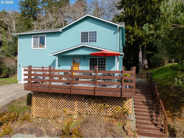 view of front of home with driveway and a deck