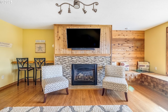 sitting room with baseboards, wood finished floors, and a tile fireplace