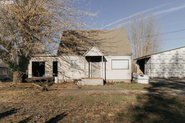 view of side of property featuring roof with shingles