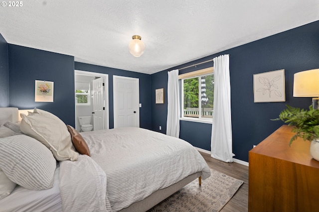 bedroom with hardwood / wood-style floors and connected bathroom