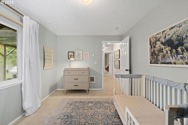 bedroom featuring light colored carpet and a textured ceiling