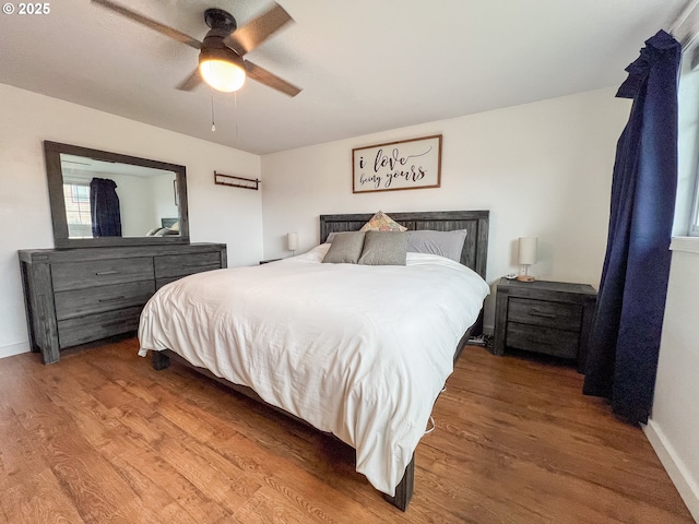 bedroom with baseboards, a ceiling fan, and wood finished floors