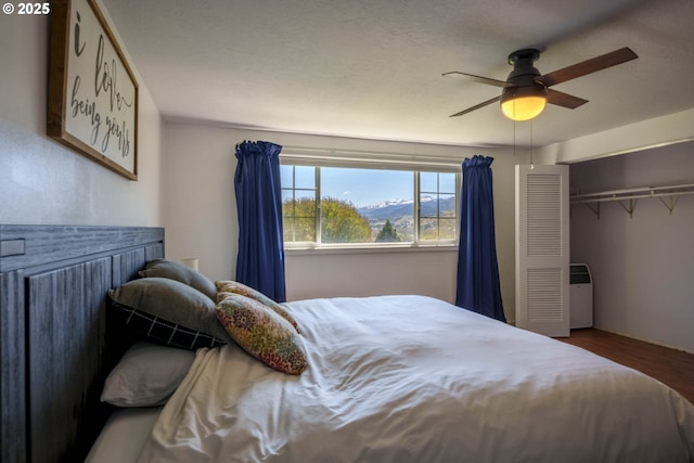 bedroom featuring wood finished floors, a closet, and ceiling fan