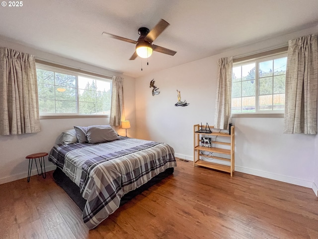 bedroom with wood finished floors, baseboards, and ceiling fan