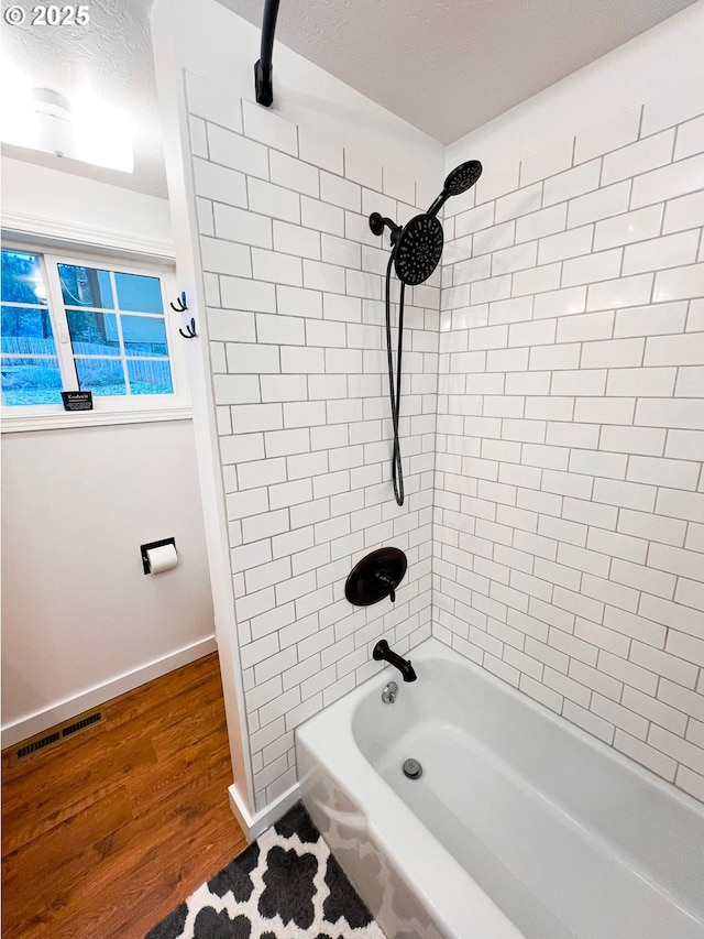 537 NW Charolais Hts, John Day, OR 97845 - bathroom featuring wood finished floors, bathing tub / shower combination, and baseboards