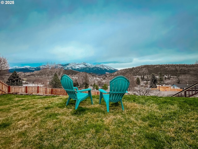 view of yard featuring a mountain view and fence