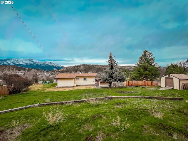 exterior space with an outdoor structure, a storage shed, fence, and a mountain view