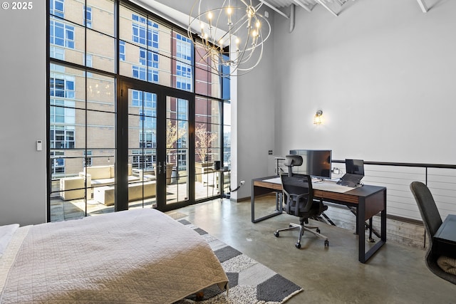 bedroom with concrete flooring, a towering ceiling, a chandelier, expansive windows, and french doors