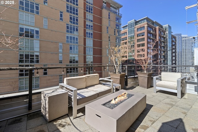 view of patio with an outdoor living space with a fire pit