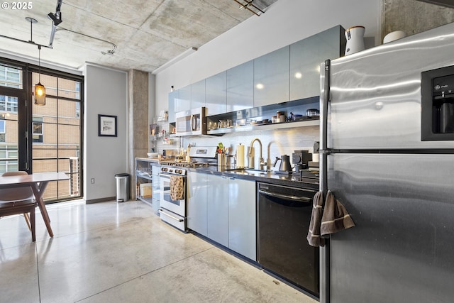 kitchen featuring floor to ceiling windows, sink, decorative light fixtures, stainless steel appliances, and decorative backsplash