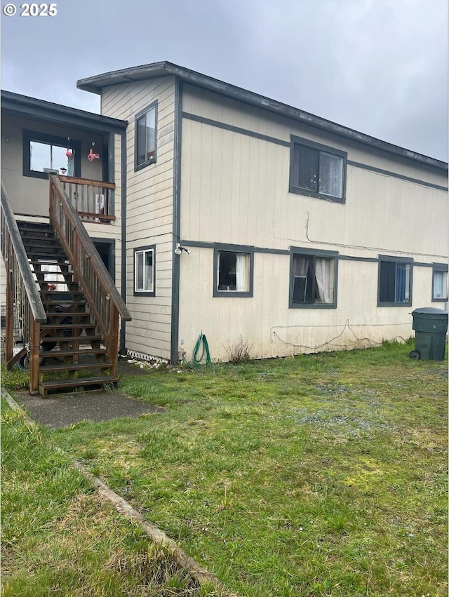 view of property exterior featuring a yard and stairway