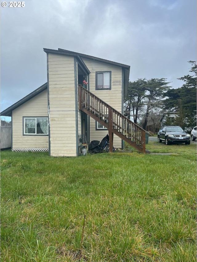 view of home's exterior featuring a lawn and stairs