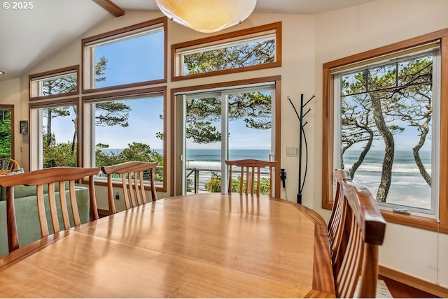 dining room featuring lofted ceiling with beams and a water view