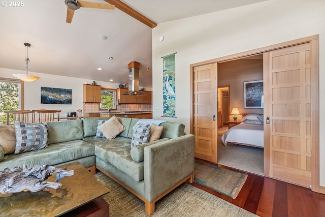 living area featuring lofted ceiling with beams, wood finished floors, and recessed lighting