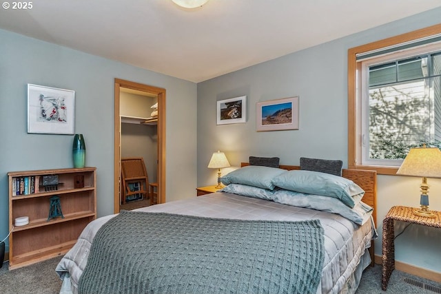 carpeted bedroom with a spacious closet and visible vents