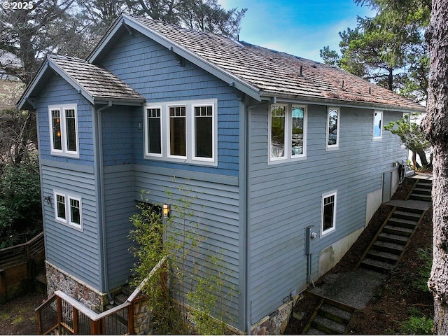 view of home's exterior featuring stairs and fence