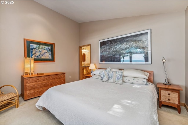 bedroom with light carpet, ensuite bathroom, baseboards, and vaulted ceiling