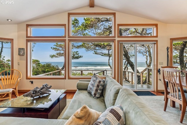 living room featuring wood finished floors, vaulted ceiling with beams, baseboards, and a water view