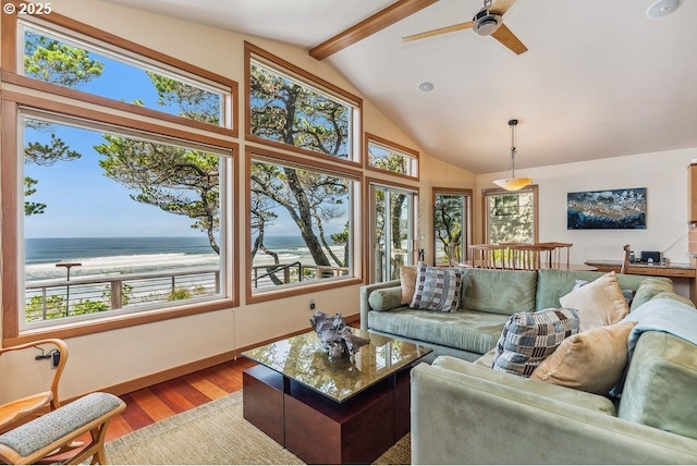 living area featuring a ceiling fan, wood finished floors, baseboards, lofted ceiling with beams, and a water view