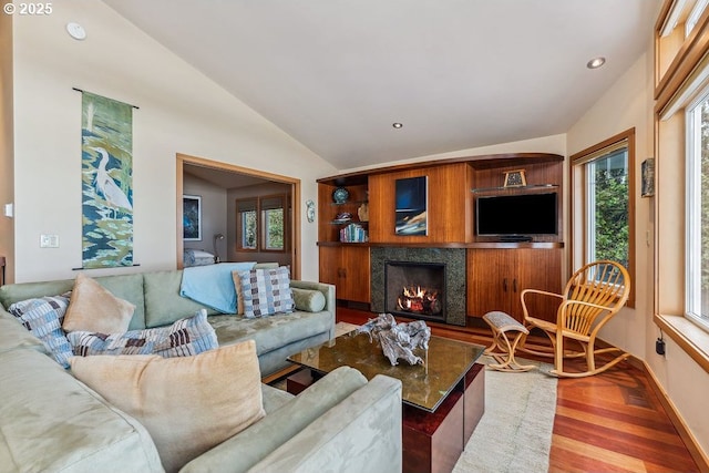 living area with baseboards, a lit fireplace, lofted ceiling, recessed lighting, and wood finished floors