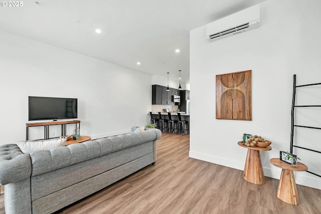 living room with a wall mounted AC and hardwood / wood-style flooring