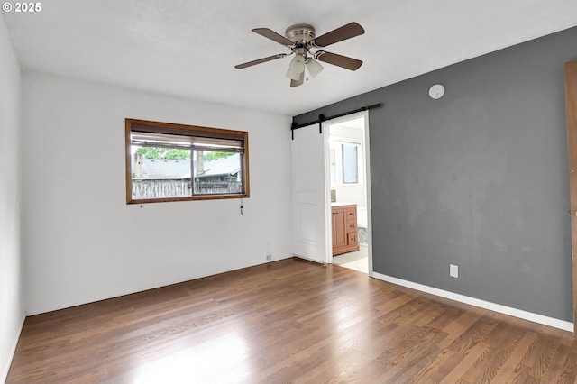 4021 N Clarey St, Eugene, OR 97402 - unfurnished room featuring a barn door, ceiling fan, and wood finished floors