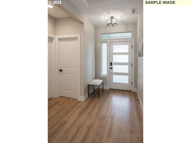 foyer with visible vents, light wood-style flooring, and baseboards