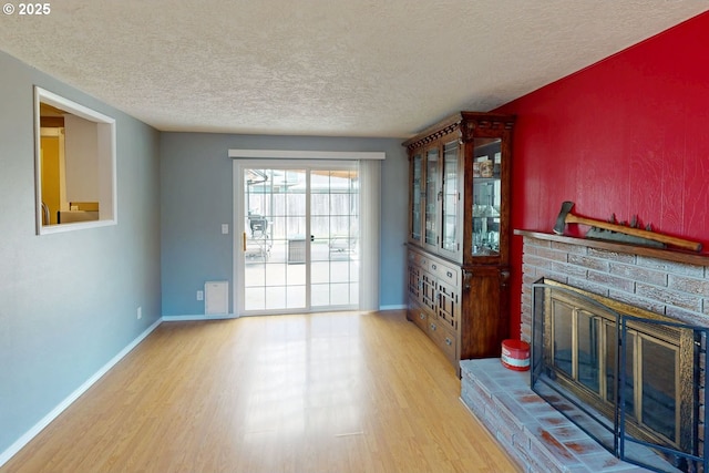 1082 Dondea St, Springfield, OR 97478 - unfurnished living room featuring wood finished floors, a textured ceiling, and a fireplace