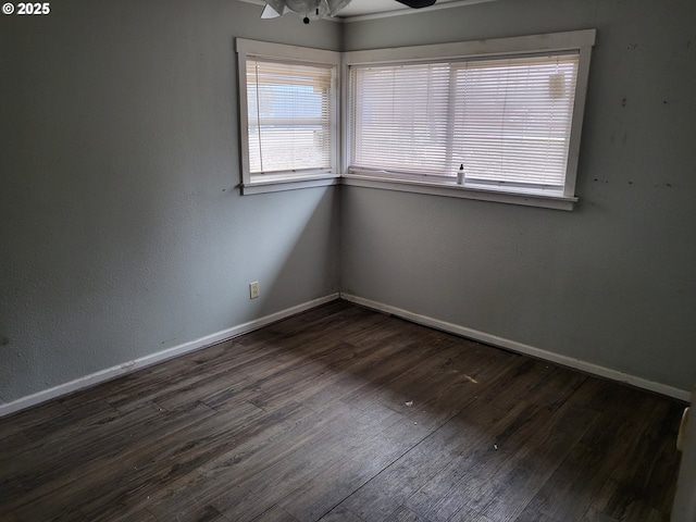 spare room featuring wood finished floors, a ceiling fan, and baseboards