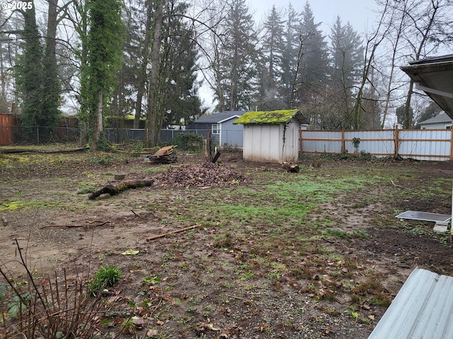 view of yard featuring an outbuilding, a storage shed, and a fenced backyard