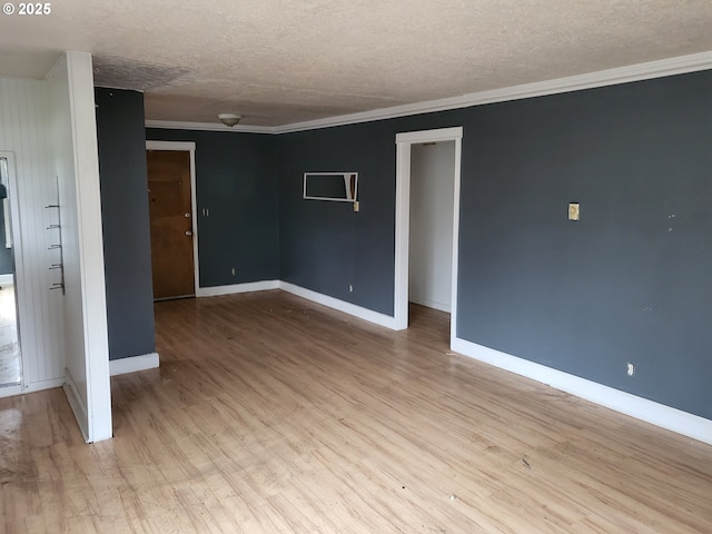 empty room with a textured ceiling, wood finished floors, baseboards, and ornamental molding