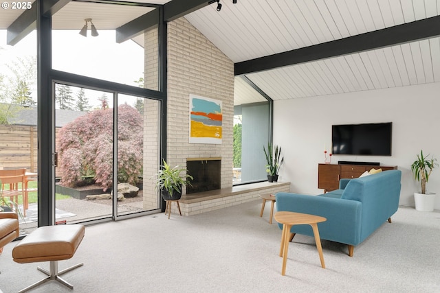living area featuring carpet flooring, lofted ceiling with beams, and a wealth of natural light