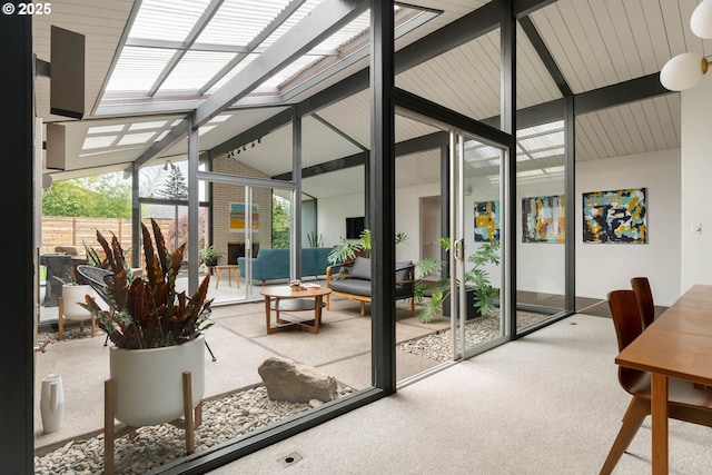 sunroom / solarium featuring a skylight and beam ceiling