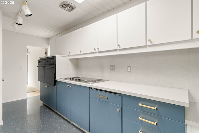 kitchen with blue cabinetry, light countertops, track lighting, electric cooktop, and oven