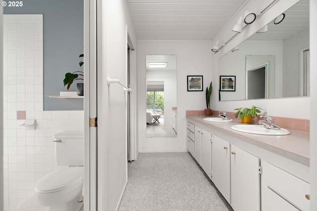 bathroom featuring a sink, toilet, and double vanity