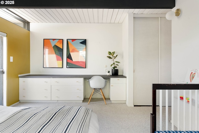 bedroom with built in study area and light colored carpet