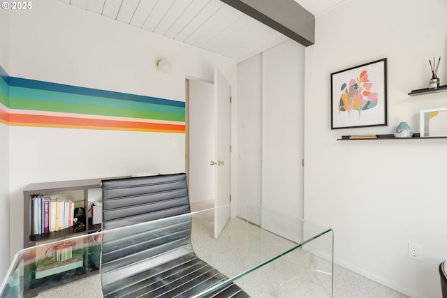 office area featuring baseboards and beamed ceiling