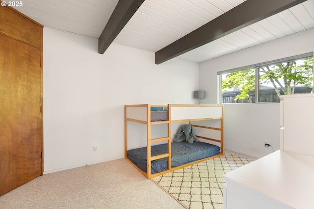 carpeted bedroom with beamed ceiling and baseboards