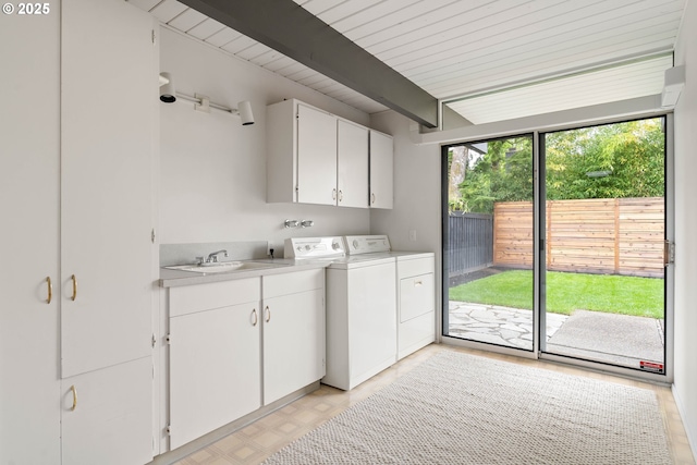 laundry area featuring a sink, separate washer and dryer, and cabinet space