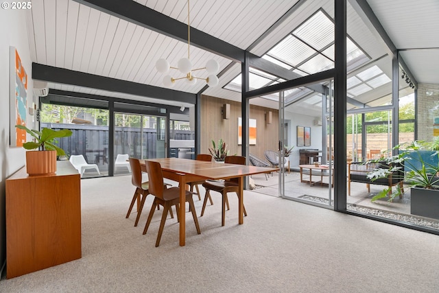 carpeted dining area featuring vaulted ceiling with beams and a chandelier