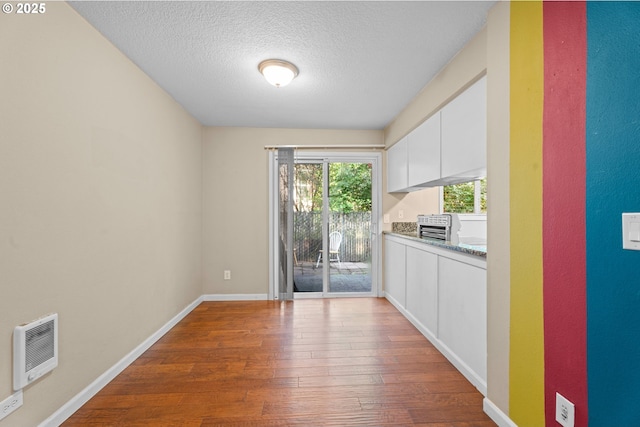 11255 SW Springwood Dr, Portland, OR 97223 - unfurnished dining area with dark wood-style flooring, heating unit, and a textured ceiling