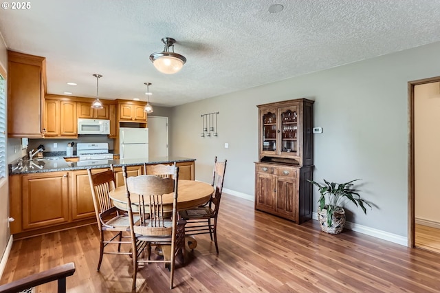 157 NE 11th Dr, Hillsboro, OR 97124 - dining area with light wood finished floors, baseboards, and a textured ceiling