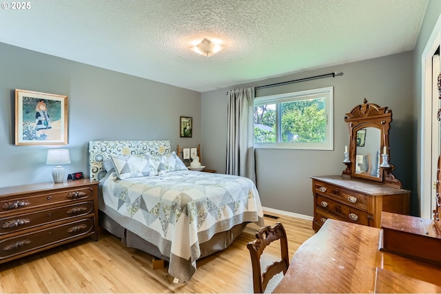 157 NE 11th Dr, Hillsboro, OR 97124 - bedroom featuring light wood-type flooring, a textured ceiling, and baseboards