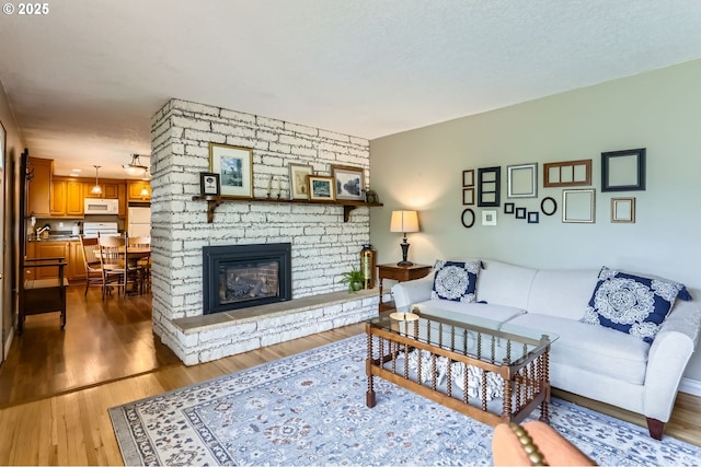 157 NE 11th Dr, Hillsboro, OR 97124 - living area with wood finished floors and a stone fireplace
