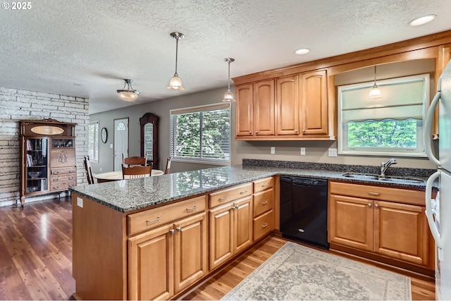 157 NE 11th Dr, Hillsboro, OR 97124 - kitchen with dishwasher, a sink, a textured ceiling, a peninsula, and wood finished floors